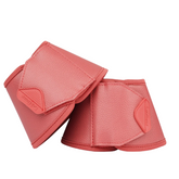 Pair of cranberry protective equestrian hoof boots on a white background